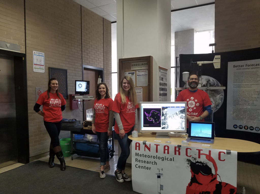 Presenters stand in front of a display